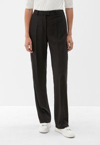 Schwarze maßgeschneiderte Hose mit glatter Textur, geradem Beinschnitt, Gürtelschlaufen und Vorderfalten. Getragen mit weißen Sneakers.