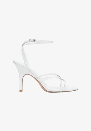 Witte sandalen met hak, voorzien van meerdere bandjes en een enkelbandje met gesp. Gladde afwerking, spits toelopende neus en een slanke, gebogen hak. Beige zoolaccent.