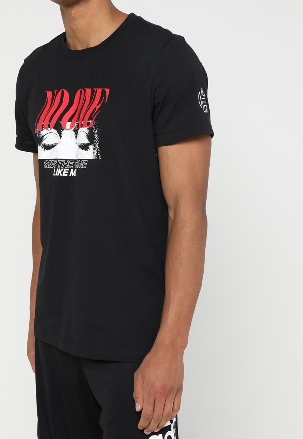 Svart bomullströja med korta ärmar, med ett grafiskt tryck med röd text och en design av slutna ögon. Accentlogga på ärmen.