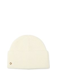Cremefarvet ribstrikket beanie med ombukket manchet og et lille metallisk spadeemblem på manchetens venstre side.