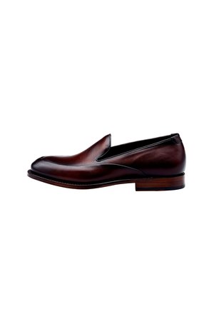 Mocassin en cuir marron à talon bas et détails de couture, présenté de côté sur fond blanc.