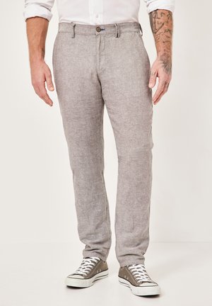 Light gray linen trousers with a straight fit, button closure, and contrasting blue accents, paired with gray canvas sneakers.