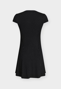 Zwarte korte mouw jurk met witte polkadotjes, getailleerde taille en uitlopende rok, van achteren getoond tegen een effen achtergrond.