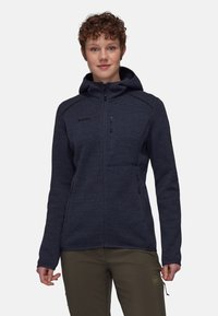 Giacca in pile con zip di colore blu navy, dotata di cappuccio, con una superficie testurizzata, due tasche laterali e una tasca sul petto con chiusura lampo.