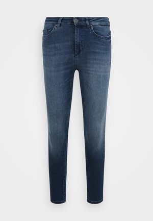 Jeans de ganga skinny-fit azul escuro com um ligeiro desbotamento, cinco bolsos e um fecho dezip padrão com botão. Textura suave e design simples.