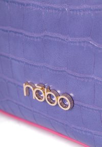 Borsa in similpelle viola con texture a cocco, caratterizzata da un logo dorato e dettagli rosa lungo il bordo inferiore.