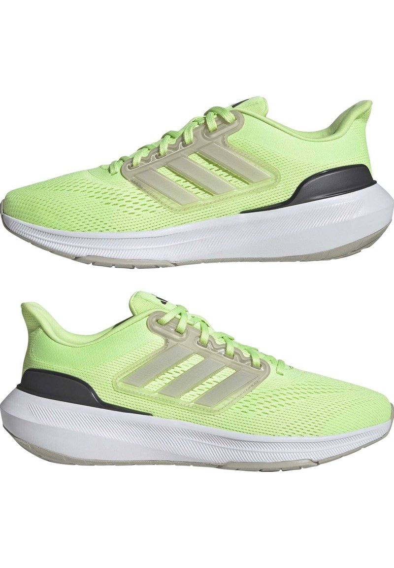 Zapatillas deportivas de color verde lima con parte superior de malla, que presentan tres rayas blancas, una cubierta de plástico y una suela blanca con un agarre texturizado.