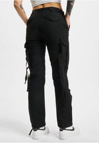 Black cargo pants with side pockets and adjustable drawstrings at the cuffs. Made of durable fabric, featuring a smooth finish and multiple details.