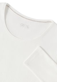 T-shirt en coton blanc avec un col rond et des manches courtes. Présente une texture subtile et une étiquette logo visible au niveau du col.