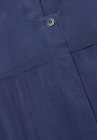 Navyblauwe button-up shirt van lichtgewicht stof, met een ronde halslijn, een enkele knoopsluiting en een gladde textuur.