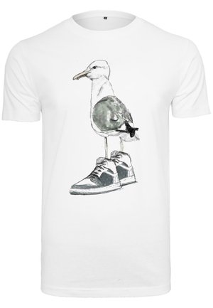 Witte T-shirt met een grafisch ontwerp van een meeuw die in een sneaker staat, met grijze en zwarte accenten op de schoen en aquareltexturen.