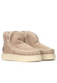 Stivaletti alla caviglia in suede beige con dettagli di cucitura intrecciata, forma arrotondata e suole in gomma color crema. Finitura morbida e texture.