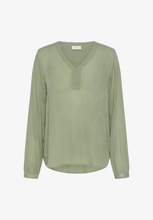 Blouse vert clair à manches longues avec un col en V et une patte décorative. Tissu doux et fluide avec un ourlet arrondi. Texture unie.