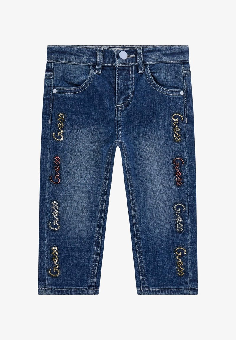 Denim jeans in dark blue, featuring five pockets, a button closure, and embroidered "Guess" logos in various colors along the sides.