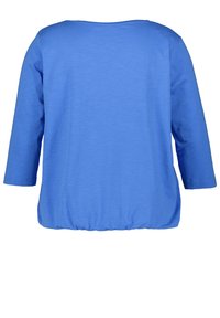 Maglia blu a maniche lunghe con scollatura rotonda e orlo arricciato. Realizzata in un tessuto morbido, presenta una superficie liscia e un design semplice.