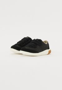 Sneaker nere con un mix di suede e materiali sintetici, dotati di cinturini in Velcro, una suola in gomma bianca e un accento in gomma marrone.