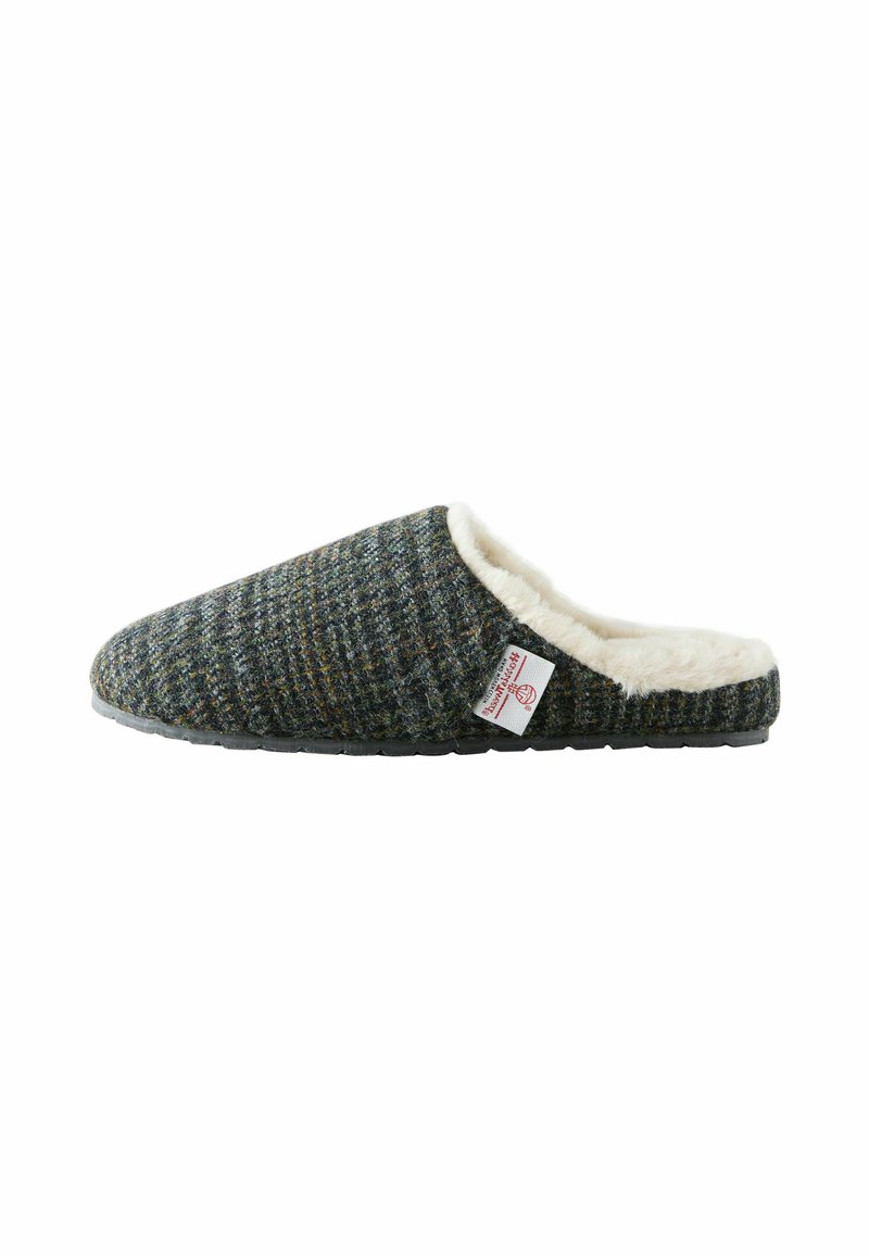 Uld-blandede hjemmesko i mørkegrå med en tekstureret overflade, cream fleece-foring og en sort gummisål. Side-tag synlig.