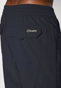 Herren Cargo-Shorts in Marineblau aus leichtem Material. Mit elastischem Bund, zwei Gesäßtaschen und einem Logo-Patch auf der rechten Tasche.