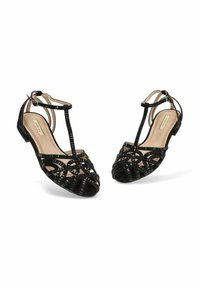 Sandalias negras de punta abierta con un diseño de tiras, que cuentan con un material texturizado y un tacón bajo. Detalladas con bandas que se cruzan y correas en el tobillo.