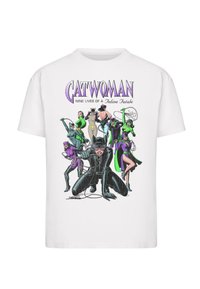 Hvid bomulds T-shirt med et farverigt grafisk design af Catwoman og andre karakterer i forskellige kostumer, der fremhæver sorte, lilla og grønne nuancer.
