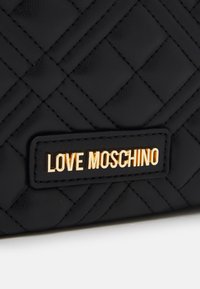 Quiltad svart läderplånbok med en guld "LOVE MOSCHINO" logoplåt, med kontrasterande sömmar och en slät yta.