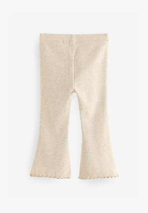 Bež rebraste trapezaste tajice sa nazubljenim rubom. Izrađene od mekanog materijala, s rastezljivim pojasom i priljubljenim krojem.