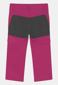 Pantalones rosa y negros con un diseño de bloques de color y costuras en contraste, hechos de una tela ligera. Incluye dos bolsillos laterales.