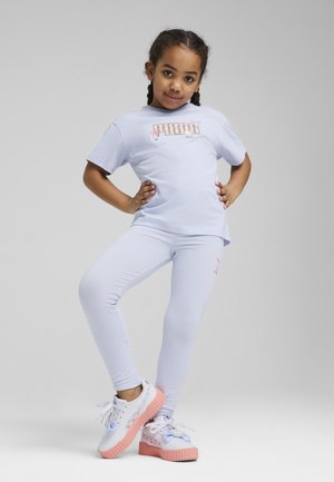 Lichtpaarse t-shirt met "PUMA" grafiek, gecombineerd met lichtpaarse leggings. Witte en roze sneakers hebben een gepatternde zool en accenten.