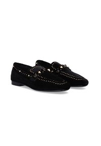 Mocasines de ante negro con tachuelas doradas y un detalle de lazo. Los zapatos cuentan con una suela plana y una forma clásica, con costuras decorativas.