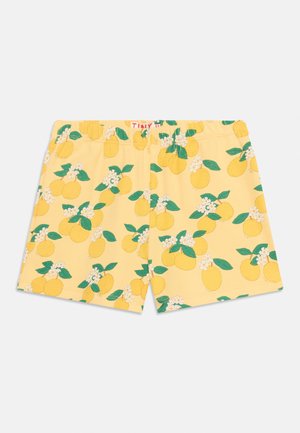 Gele kindershorts met een elastische tailleband, versierd met een patroon van citroenen, groene bladeren en kleine witte bloemen.