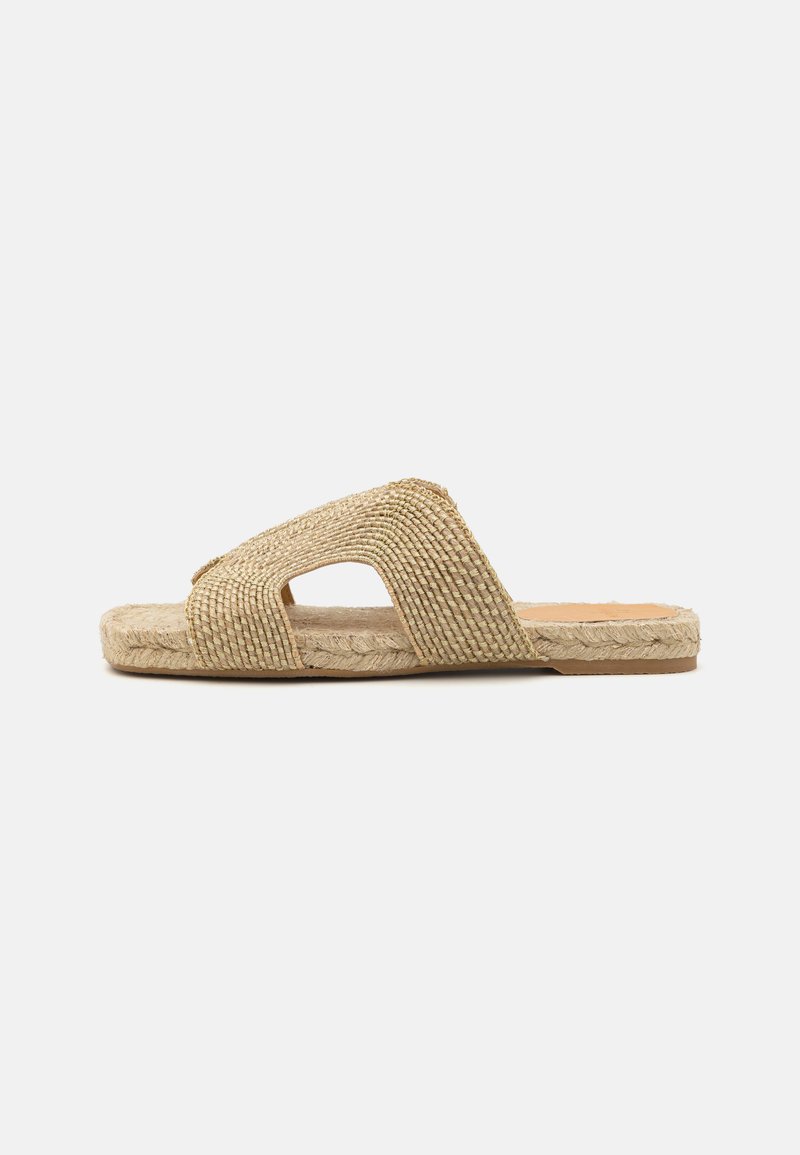 Beige espadrille slide sandal with woven fabric band, featuring two cut-out sections. Natural jute sole with braided detail. Flat design.