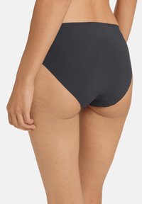 Costume da bagno nero a vita alta realizzato in tessuto morbido, caratterizzato da un design pulito con cuciture minime e una vita elastica.