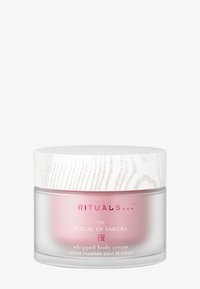 Vispad kroppskräm i en behållare med frostat rosa glasunderlag och texturerat vitträdslock. Etiketten har rosa text och blommönster.