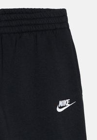 Fekete szabadidőnadrág elasztikus derékrésszel és egy kis fehér Nike logóval a bal oldalon. Puha pamut anyagból készült.