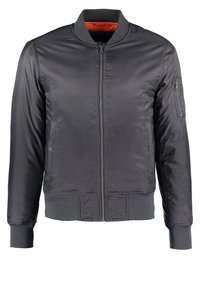 Veste bomber noire avec fermeture éclair frontale, poignets et ourlet côtelés, poches latérales à pression, et poche zippée sur la manche gauche, doublure intérieure orange visible.