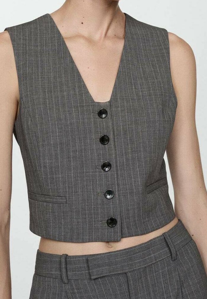 Chaleco corto a rayas grises con escote en V profundo, seis botones negros y bolsillos laterales. La tela parece suave con un ajuste entallado.
