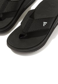 Zwarte slipper sandalen met een gestructureerde band en een gevoerde zool. De band heeft een gaas detail en een klein logo-accent.