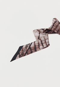 Καφέ και μαύρο φουλάρι με μοτίβο tie-dye, με μαύρες γεωμετρικές ρίγες και μικρό λευκό λογότυπο σε μια μυτερή άκρη, σε απλό ανοιχτό φόντο.