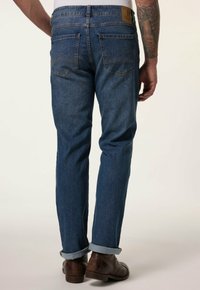 Dark blue denim jeans with a straight cut, featuring rolled cuffs, two back pockets, and a tan leather patch on the waistband.