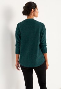 Dunkelblauer Strickpullover mit rundem Ausschnitt und Dreiviertelärmeln, der ein leicht strukturiertes Finish und einen abgerundeten Saum aufweist.