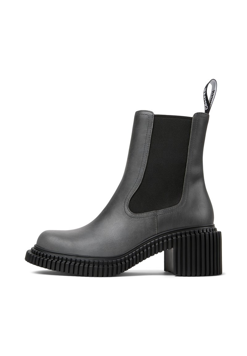 Grijze leren enkelboot met een zwarte elastische zijpaneel, ronde neus en chunky ribbelhak. Voorzien van een trekband aan de achterkant.