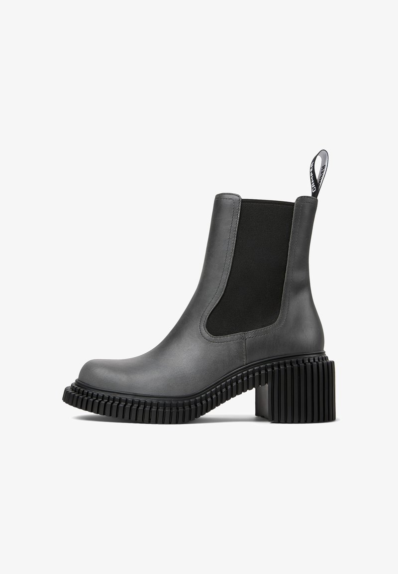 Šedá kožená kotníková bota s černým elastickým bočním panelem, zaoblenou špičkou a robustním ribovaným podpatkem. Obsahuje poutko na zadní straně.
