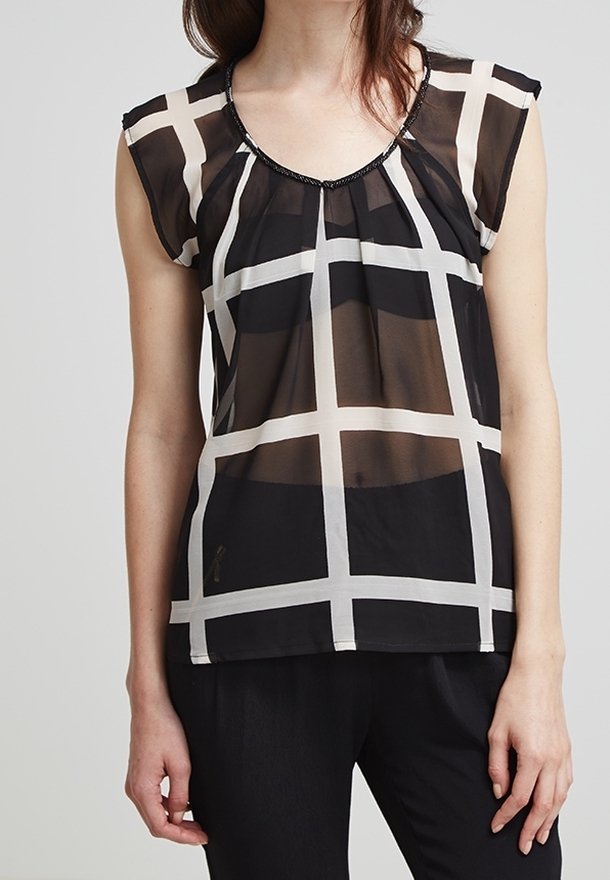 Svart och vit rutigt blus med korta ärmar, rundad halsringning och pärldetaljer. Tillverkad av ett lätt, genomskinligt tyg.