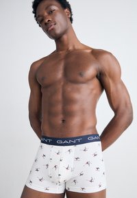 Hvite boxer shorts med skifest i grønt og rødt, med en marineblå linning med "GANT" logo. Mykt bomullsmateriale og tettsittende design.