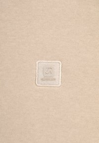 Tessuto beige con una superficie liscia, caratterizzato da un'etichetta logo quadrata nell'angolo inferiore, denominata "GABBIANO" in lettere in rilievo.