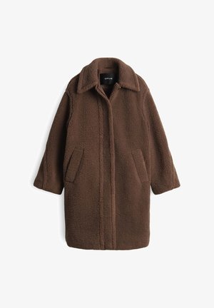 Manteau en polaire marron avec col, manches longues et deux poches avant. Présente un design épuré et minimaliste avec des coutures verticales.