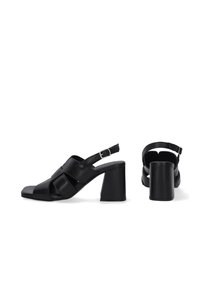 Zwarte leren slingback sandalen met een vierkante neus, hoekige uitsparingen en een taps toelopende blokhak; sluit met een verstelbare band.