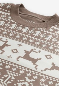Bruine trui met een winterpatroon van witte rendieren, sneeuwvlokken en geometrische vormen. Ribgebreide halslijn en textuurstof.