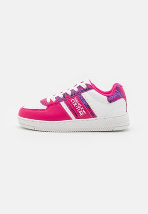 Low-top sneaker med hvid sål, hvid og lyserød læderoverdel, lilla blomsterdetaljer og "Versace Jeans Couture" branding på siden.