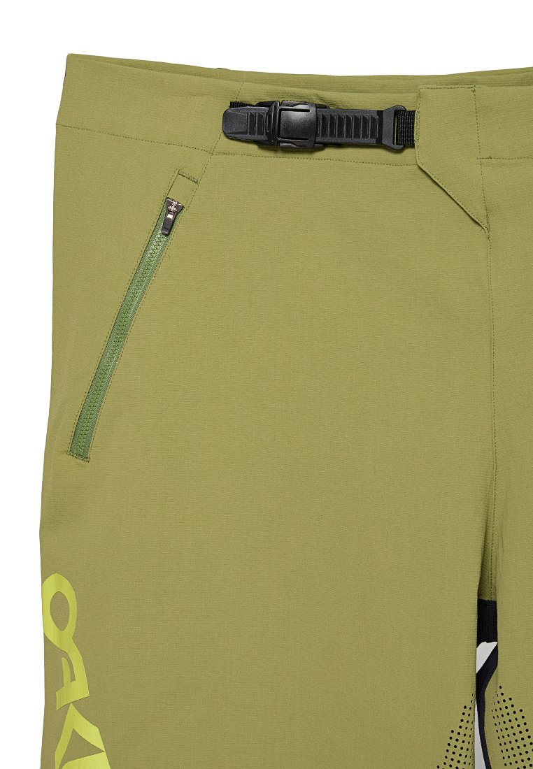 Grüne, leichte Hosen mit einer Reißverschlusstasche, verstellbarem Bund mit Schnalle und einem schwarzen Akzent mit gepunktetem Muster.